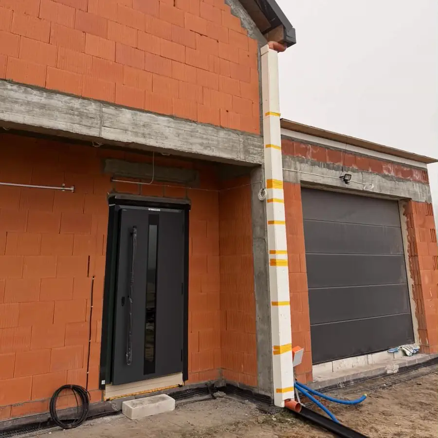 Realizacja — drzwi wejściowe i brama garażowa w domu w stanie surowym