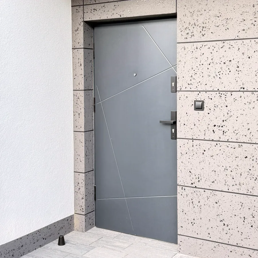 Realizacja — drzwi wejściowe antracytowe w elewacji z betonu architektonicznego